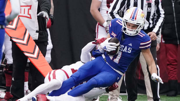 Oct 28, 2023; Lawrence, Kansas, USA; Kansas Jayhawks wide receiver Luke Grimm (11) runs the ball as Oklahoma Sooners defensive back Kendel Dolby (15) makes the tackle during the second half at David Booth Kansas Memorial Stadium. Mandatory Credit: Denny Medley-USA TODAY Sports  